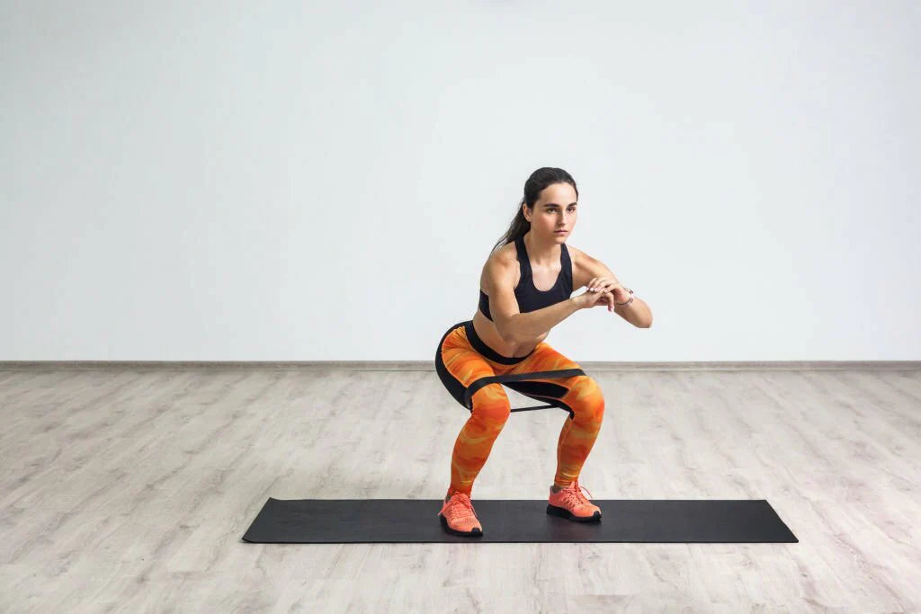 Demi squats avec bande élastique pour l’activation des quadriceps