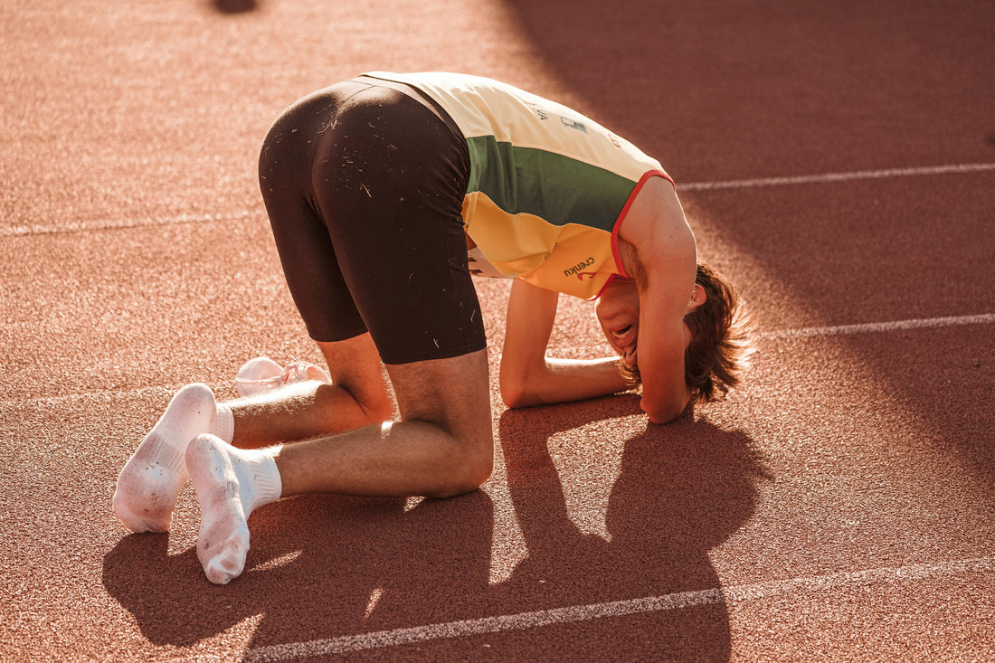Homme fatigué sur une piste d'athlétisme
